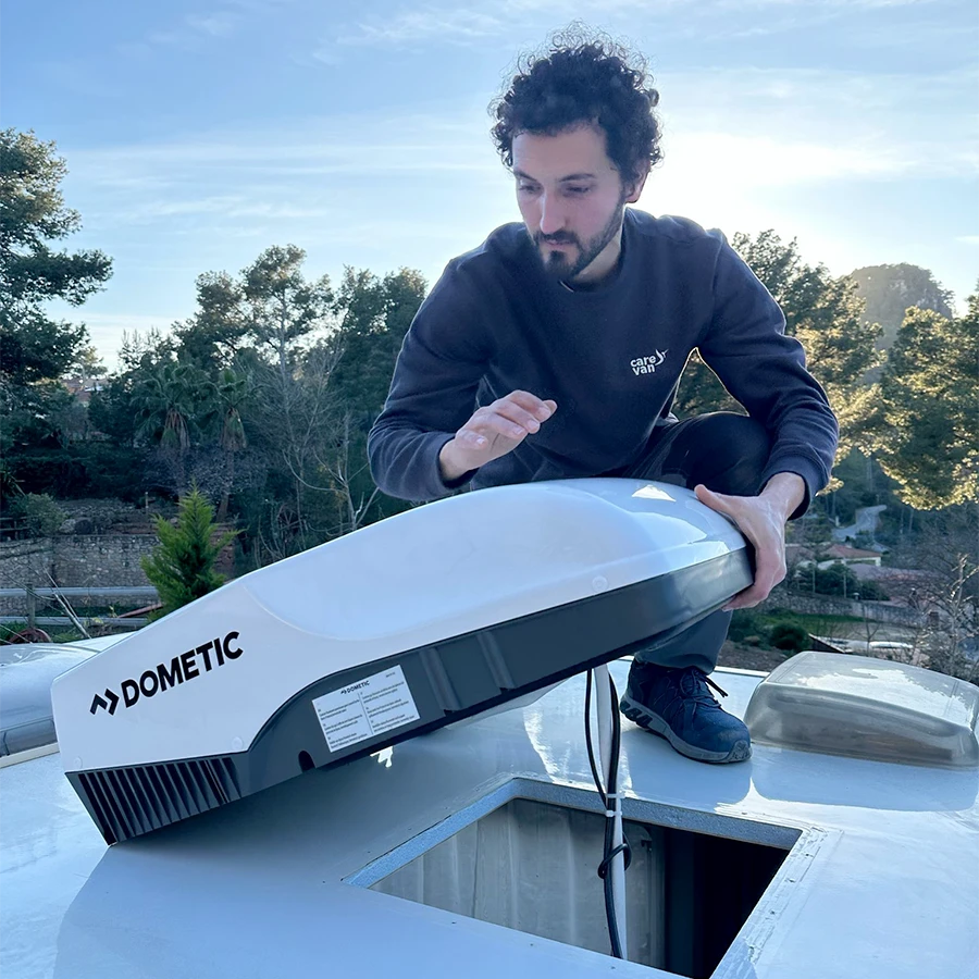 Técnico de Carevan subido en el techo de la caravana